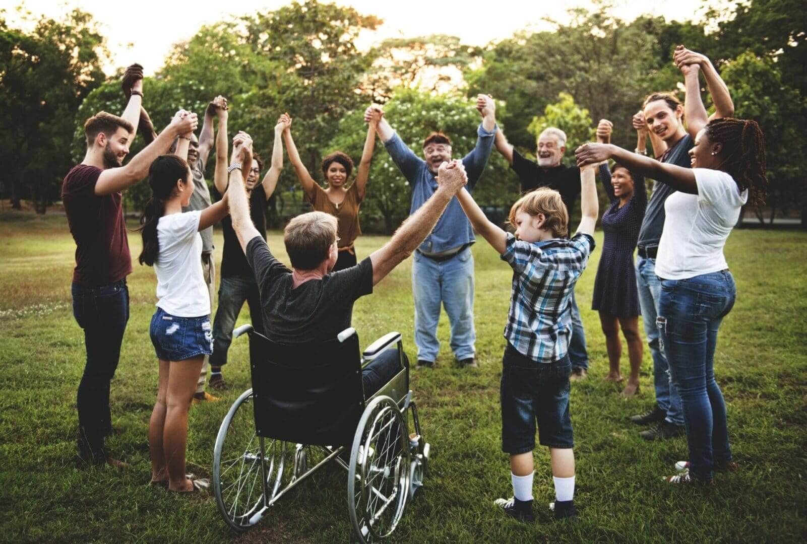 A group of people standing around each other in the grass.