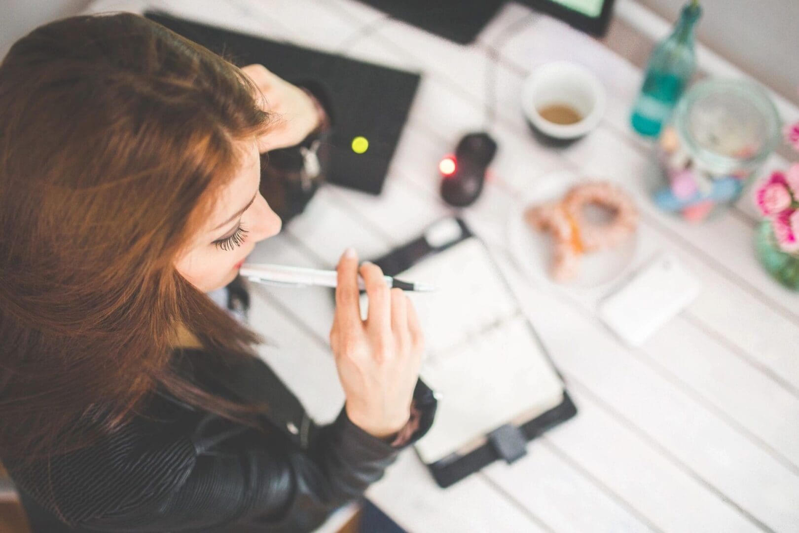 A woman sitting at a table with a cup of coffee.