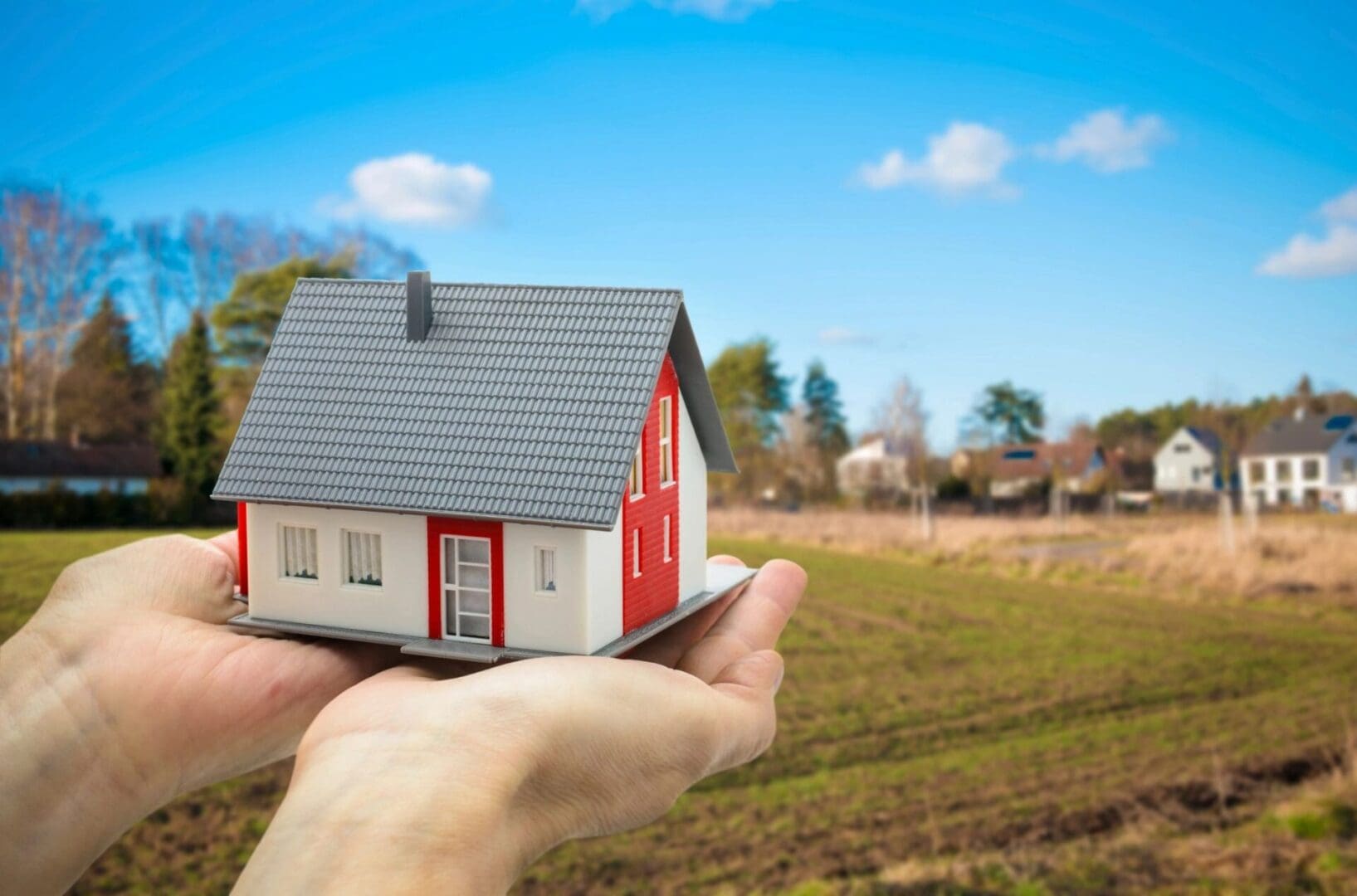 A Person Holding A House On Hand